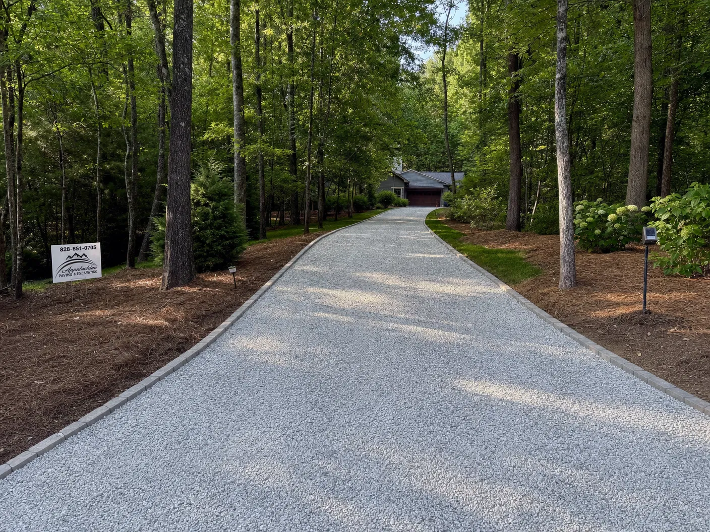 Gravel driveway installation through wooded property